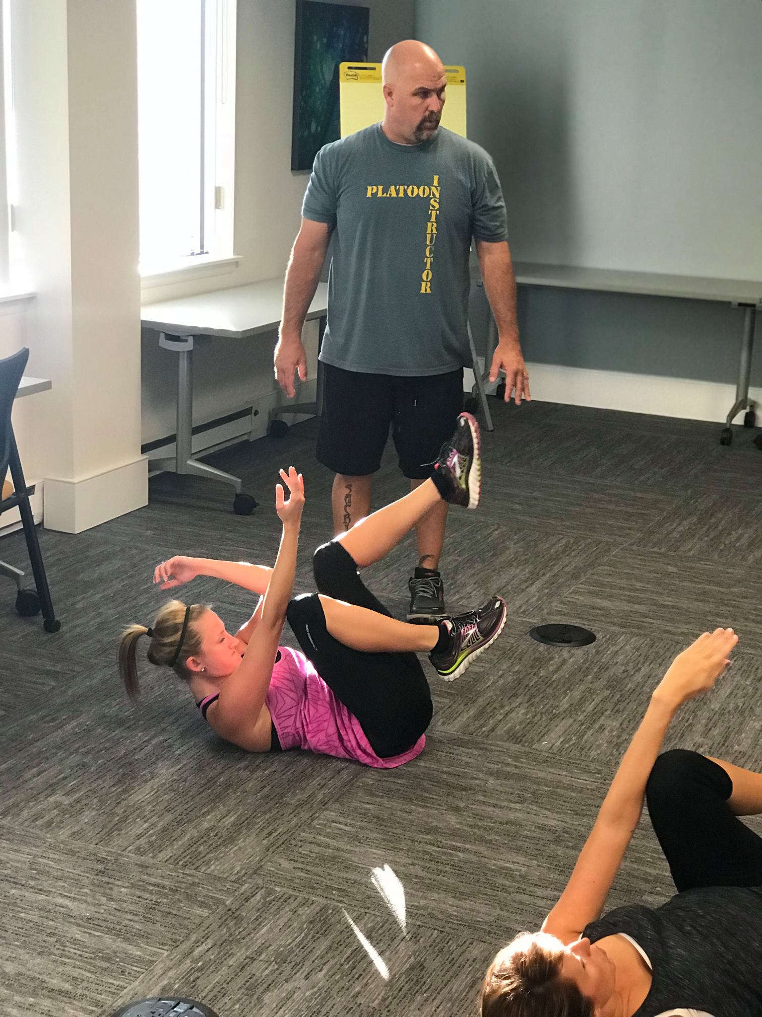 A woman is falling on the ground in an office.