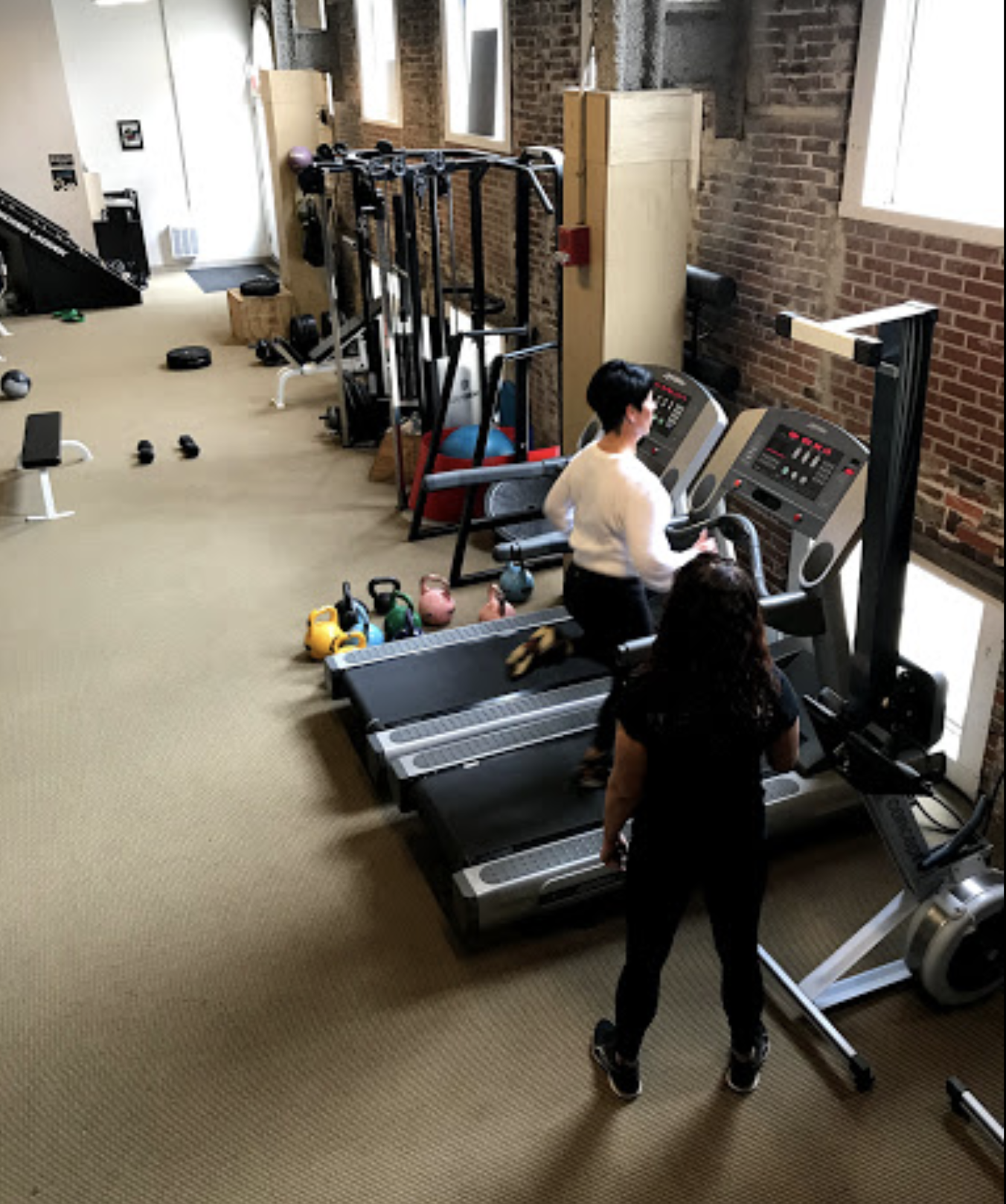 A couple of people in a gym with some equipment.