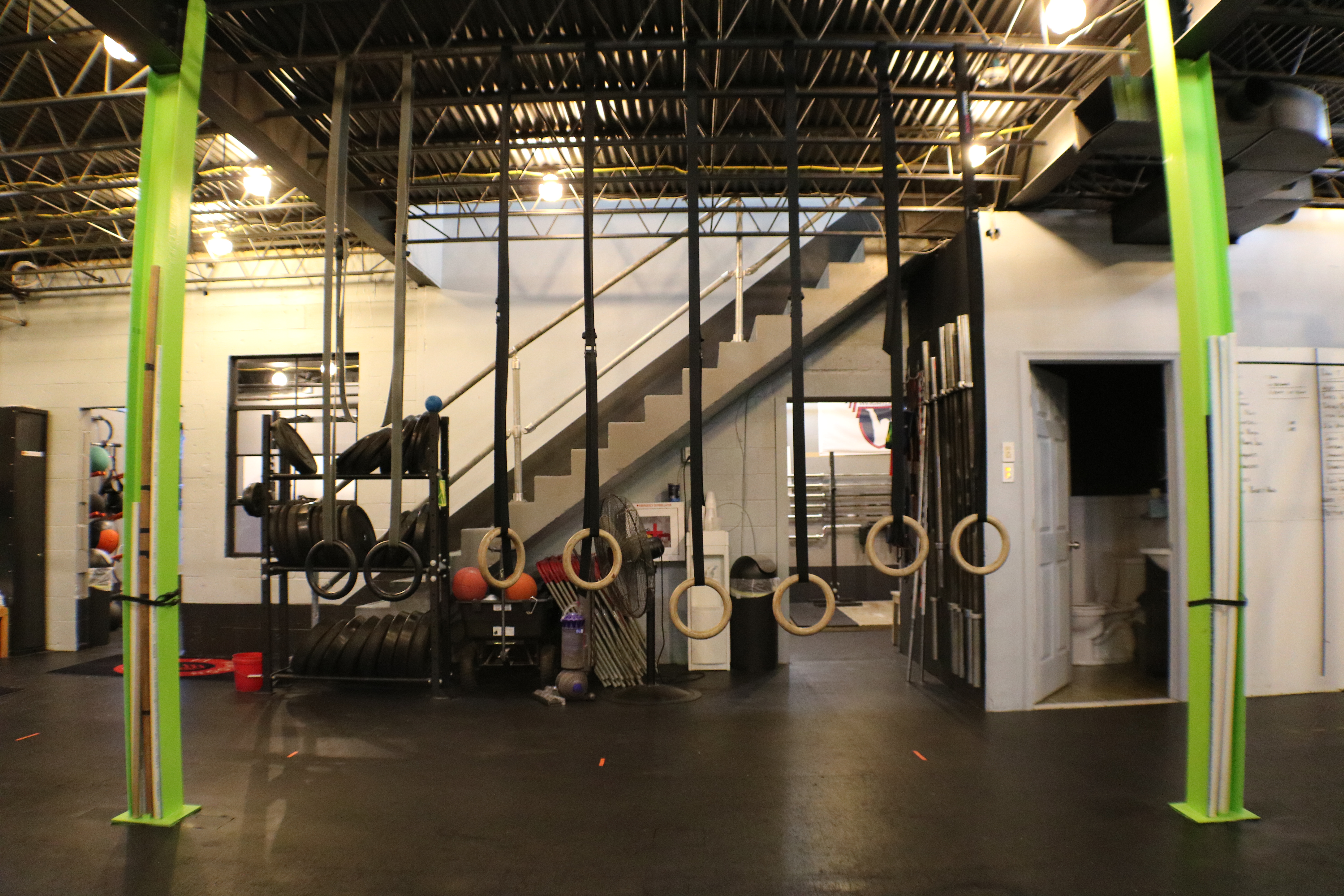 A gym with several large hanging tires and stairs.