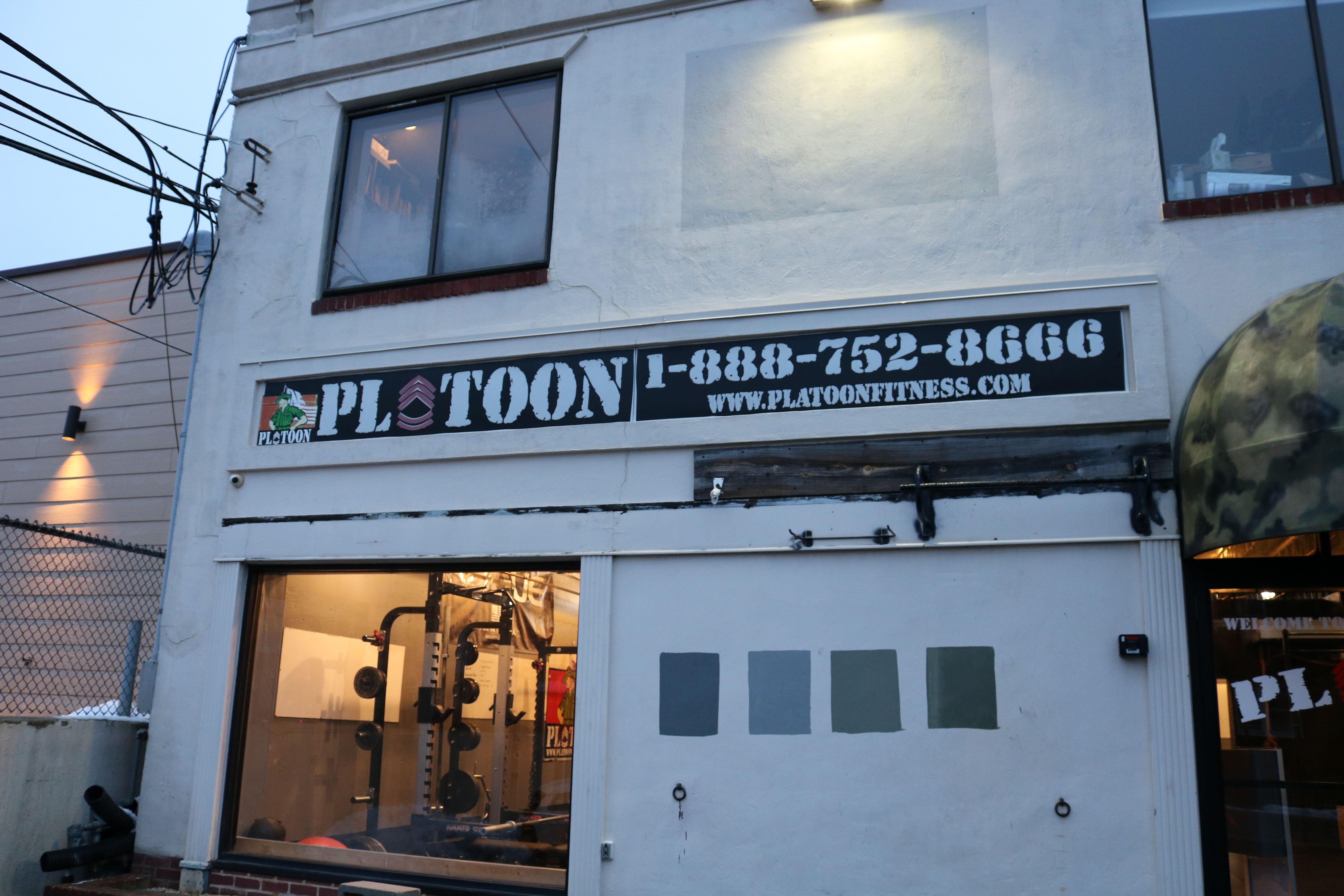 A building with a sign that says plotoon 1-8 8 8-7 5 2-8 6 0 6.