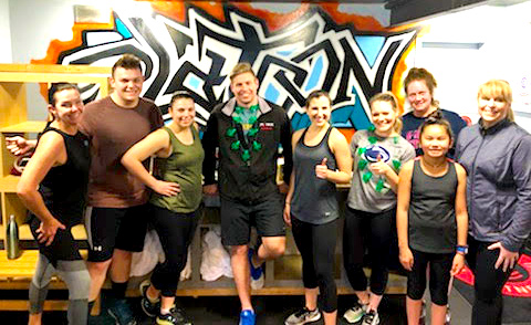 A group of people standing in front of graffiti.