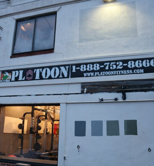 A building with a sign that says plotoon 1-8 8 8-7 5 2-8 6 0 6.